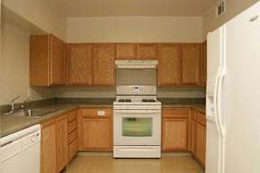 A kitchen with wooden cabinets and a white refrigerator.