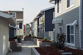 A row of houses with a sidewalk in between.
