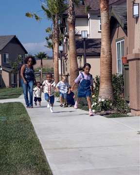 A family of four walking down a sidewalk.
