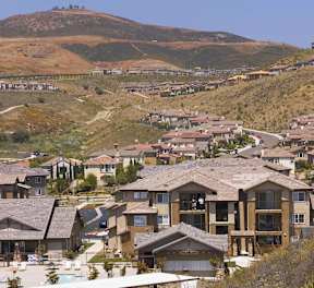 A residential area with houses and a mountain in the background.