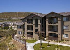 Apartment complex with a walkway and greenery.