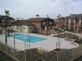 A pool surrounded by a fence in a residential area.