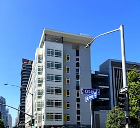 A tall white building with a blue street sign in front of it.