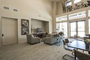 A living room with a couch, chairs, and a television.