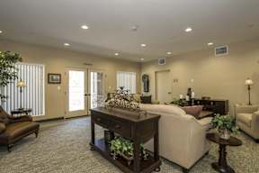 A living room with a brown sofa, a white couch, and a wooden coffee table.