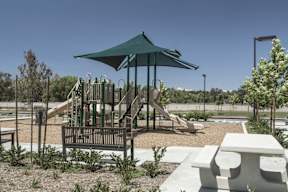 A playground with a green canopy and a slide.
