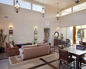 A living room with a brown couch, a coffee table, and a dining table.