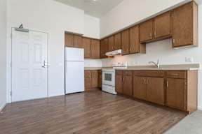 A kitchen with wooden cabinets and a white fridge.
