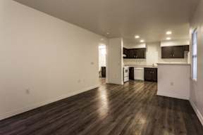 A large empty room with wooden floors and white walls.