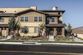 A beige house with a black roof and a grey dome on top.