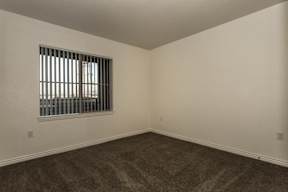 A room with a window and carpeted floor.