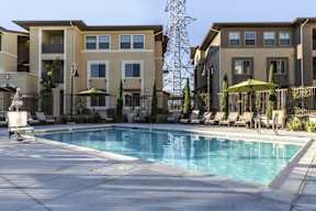 A swimming pool in front of apartment buildings.