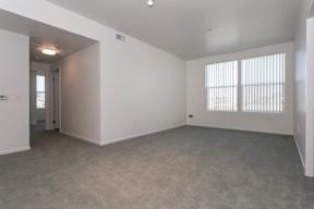 A large empty room with a door and a window.