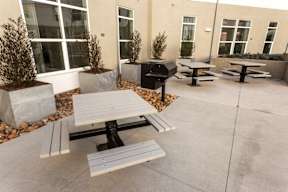 A concrete patio with a table and benches.