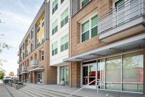 A modern building with a balcony and glass doors.