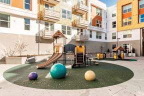 A playground with a slide, swings, and a ball.