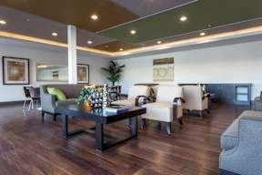 A living room with a dark wood floor and a variety of seating options.