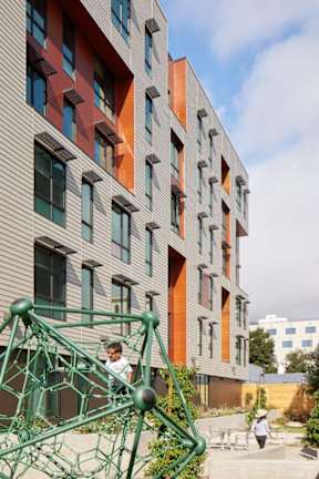 A modern building with a green metal structure in front.