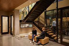 Two people sitting on a bench in a modern interior space.