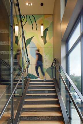 A staircase with a glass railing and wooden steps.
