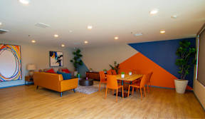 A living room with a couch, chairs, and a dining table.