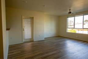 A room with wooden floors and a ceiling fan.