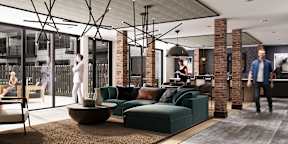 Stylish resident lounge at Contrast OTR in Cincinnati, Ohio, featuring exposed brick accents, modern lighting fixtures, plush seating, and floor-to-ceiling windows for an upscale urban living experience