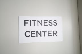 a white sign that reads fitness center on a white wall