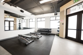 a fitness room with weights and dumbbells on the floor