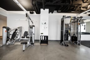 a gym with weights and other equipment in a room with white walls