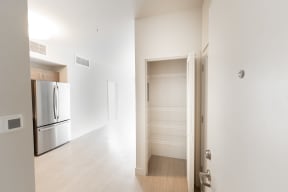 an empty room with a refrigerator and a closet