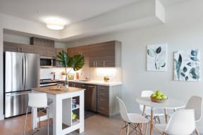 Apartments in San Rafael for Rent - Second and B Street - Open Kitchen and Dining Area with Stainless Steel Appliances, a Kitchen Island, and a Circular Dining Table with Four Chairs