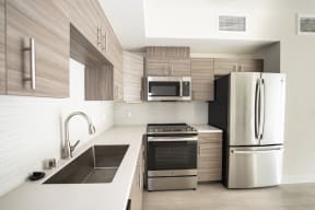 a modern kitchen with stainless steel appliances and wooden cabinets