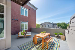 Apartments for Rent in San Rafael - Second and B Street - Private Balcony with a Table and Two Benches for Seating, Two Chairs with Footrests, and a View of the City