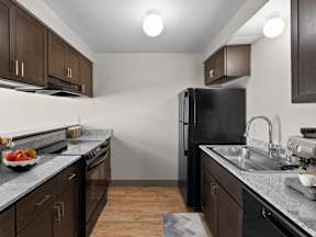 A kitchen with black appliances and wooden cabinets at ALTITUDE BY VINTAGE, Reno