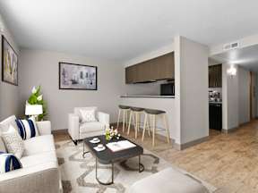 A living room with a white couch, a coffee table, and a kitchen area in the background at ALTITUDE BY VINTAGE, Reno, Nevada
