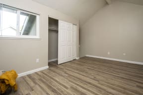 Bedroom with large closet and plank flooring