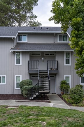 Rohnert Park Apartments - Americana - Grey and Black Apartment Building with Iron Staircase and Greenery