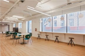 a large room with wooden floors and a long counter with stools and tables at K Street Flats, California, 94704
