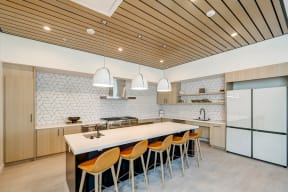 a large kitchen with a long island with a white countertop and a row of orange chairs at Westlook, Nevada