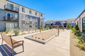 a bench sits on a concrete patio in front of a row of apartment buildings at Westlook, Reno Nevada