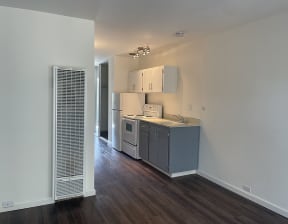 Apartments for Rent in North Oakland, CA - 225 Clifton - Kitchen Area with Grey Cabinets, Spacious Countertops, and White Kitchen Appliances