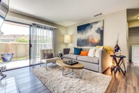 Pittsburg CA Apartments - Open Space Living Room with Stylish Interiors and Hardwood Floor Featuring Sliding Door to Patio