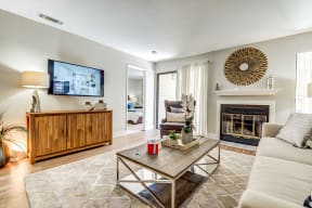 Pittsburg CA Apartments - Kirker Creek - Spacious Living Area with Wood Flooring, Sliding Glass Patio Door, Fireplace, and White Walls
