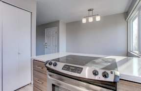 A modern kitchen with a stainless steel oven and a white cabinet.at Tigardville Apartments, Tigard, OR 97223