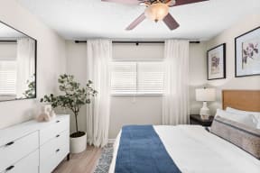 a bedroom with a ceiling fan and a window with white curtains at The Bentley at Maitland, ORLANDO