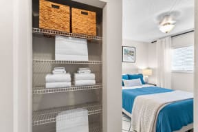 a bedroom with a bed and a closet with folded towels at The Bentley at Maitland, ORLANDO Florida