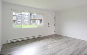 A room with a large window overlooking apartment buildings.at Tigardville Apartments, Oregon