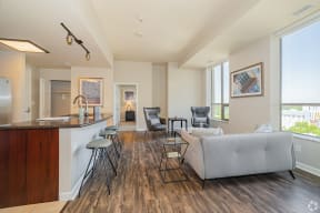 Downtown Sacramento, CA Apartments for Rent- The Penthouses at Capital Park- Living Room with Modern Furniture, Wood-Style Flooring, Large Window, and Access to the Kitchen