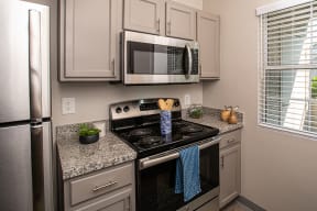 Apartments in Sparks for Rent - High Rock 5300 - Galley Kitchen with Stainless Steel Appliances, Granite Countertops, and Grey Cabinetry